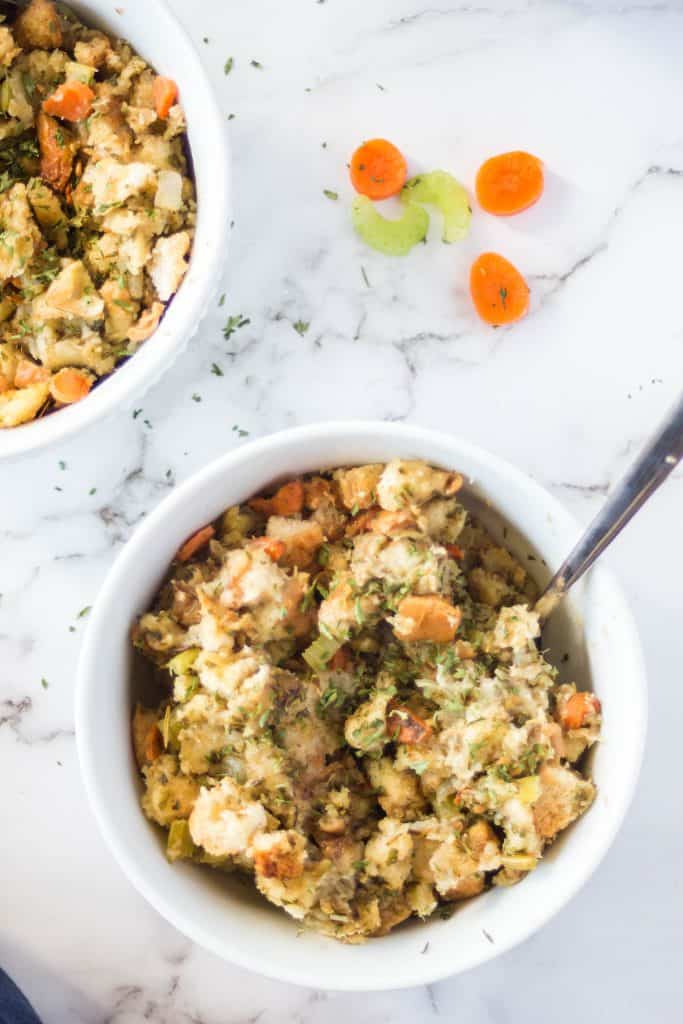 vertical image of slow cooker stuffing in a white bowl